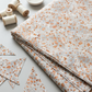 Terrazzo Coastal Path Fabric by Riley Blake Designs folded on a light-gray table beside matching triangular remn