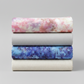 Fire & Ice by Maywood Studio cotton quilting fabric collection folded and stacked showing Peach Ice Dye and coordinating colorways on light grey background