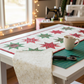 Winter Solstice II Cream Snowflakes Metallic Fabric by Jason Yenter for In The Beginning Fabrics — shown as the background fabric in a Christmas star table runner work in progress, cozy sewing room with fairy lights, vintage sewing machine, and a mug of tea in the background. Quilt blocks shown for inspiration. Coordinating fabrics and quilt patterns are available at IraRobi Quilts.