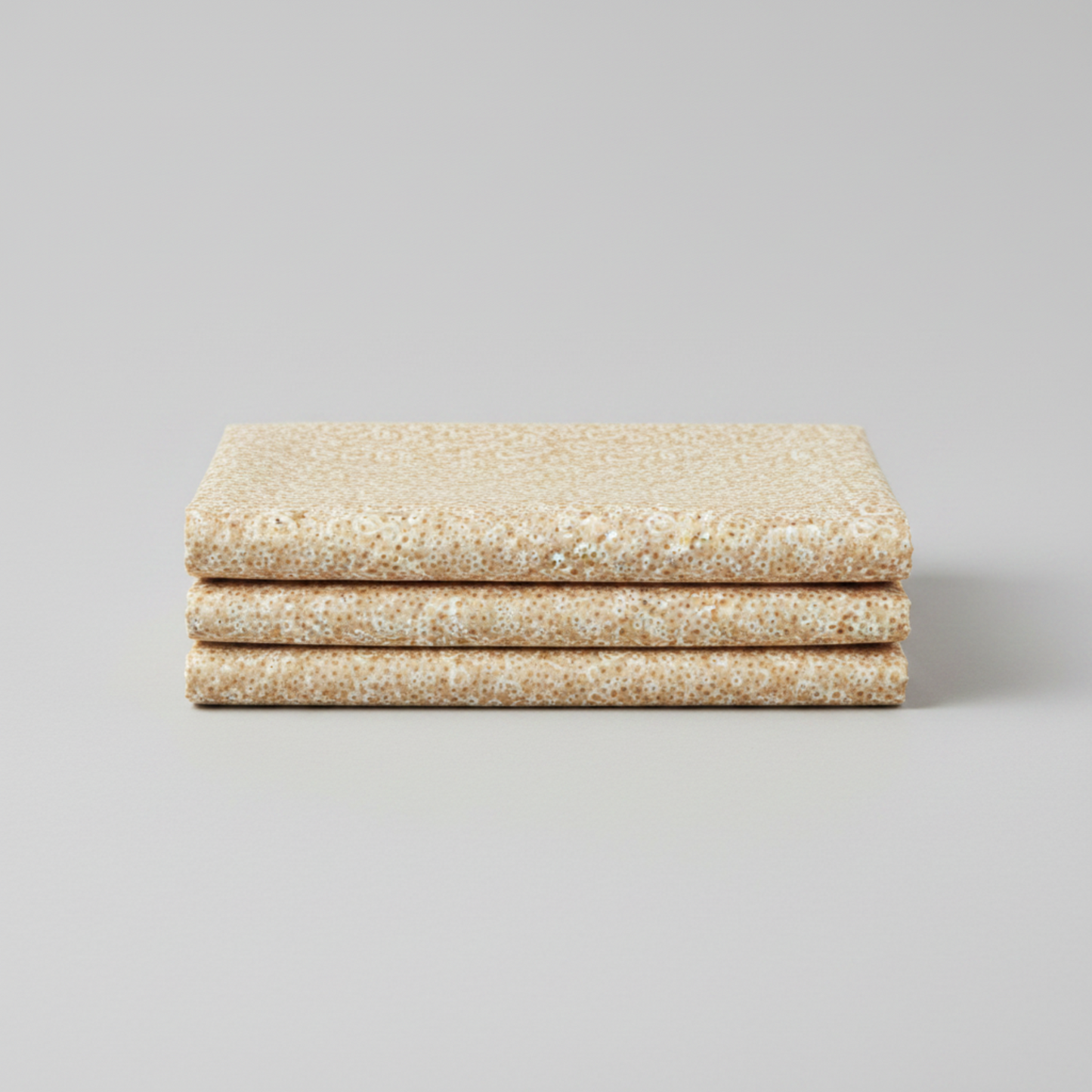 The Fox Homestead Cream Swirl Floral Texture quilting cotton in soft fold stack — warm sand with tossed white paisley swirls and rust gold dots by Stacy West for Henry Glass