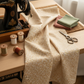 The Fox Homestead Cream Swirl Floral Texture quilting cotton by Stacy West for Henry Glass — styled sewing room flat lay with fabric alongside vintage sewing machine, cream and rust thread spools, scissors, and dusty rose and sage fabric swatches