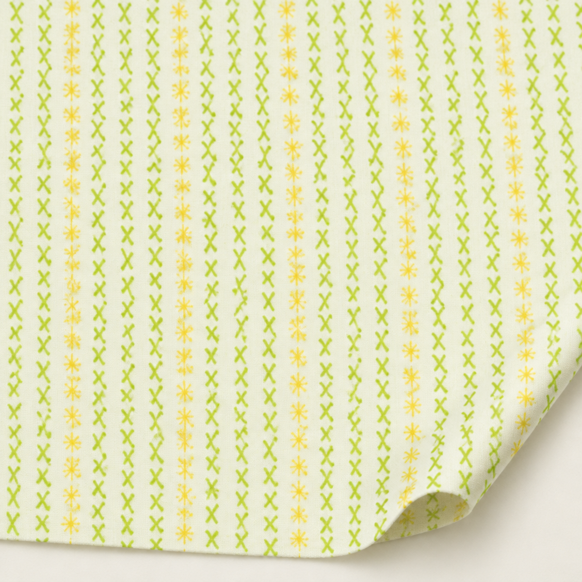 Dandi Duo Cream fabric by Robin Pickens for Moda Fabrics, with vertical lime-green stitched X marks and tiny yellow starbursts on cream.