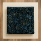 Folded Color Play Mottled Rainstorm fabric by Riley Blake Designs on an ivory surface, showing deep blue-teal, charcoal, and olive tones.