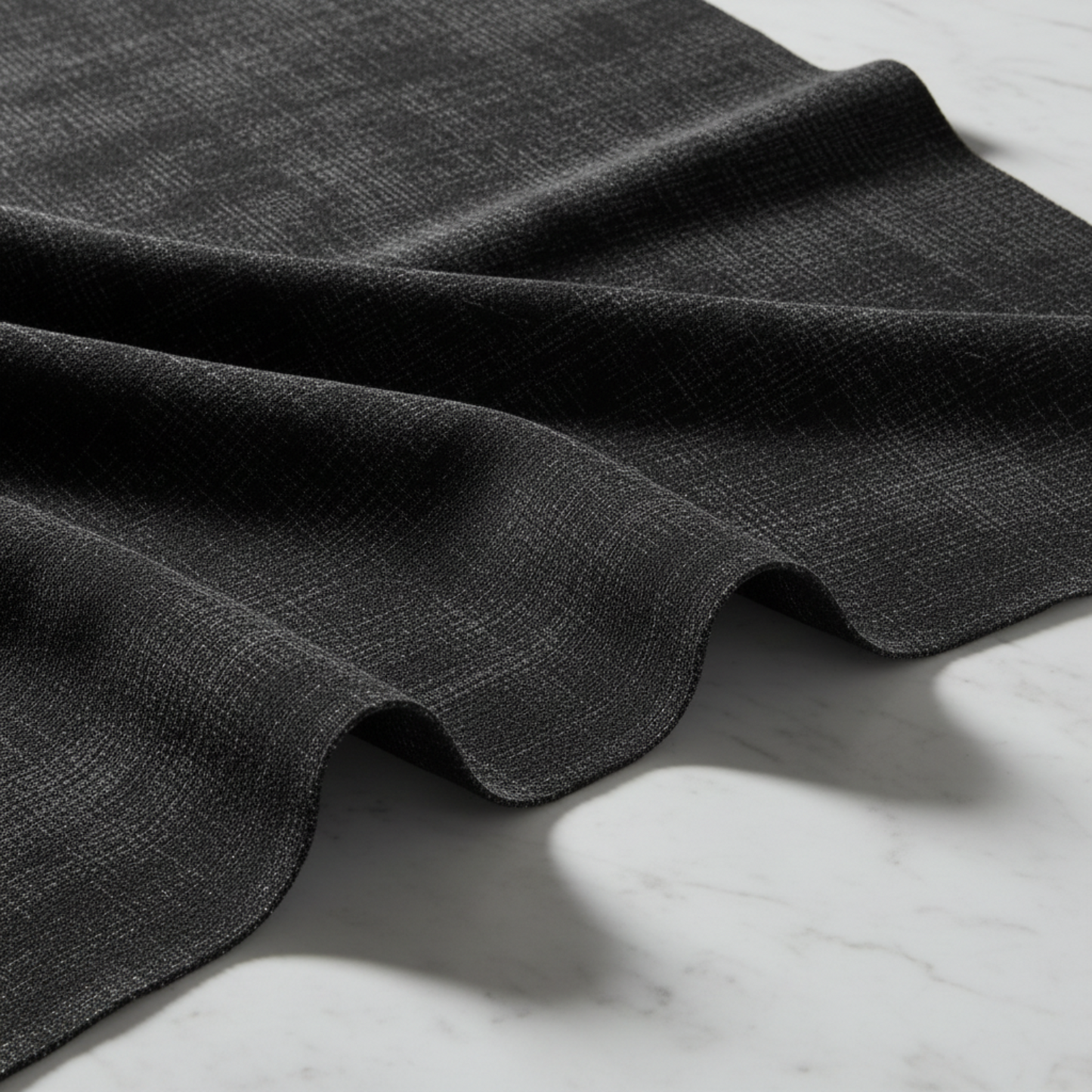 Interwoven Dark Slate quilting fabric draped on white marble – deep dark charcoal geometric crosshatch texture with crisp modern styling – 100% cotton quilting fabric by Jason Yenter for In The Beginning Fabrics
