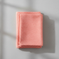 Dotty Thatched Carnation quilting cotton by Robin Pickens for Moda Fabrics — neatly folded in a stack on a light grey background showing the warm coral-pink ground with scattered tonal dots. 100% cotton, 43–44" wide. Available at IraRobi Quilts.