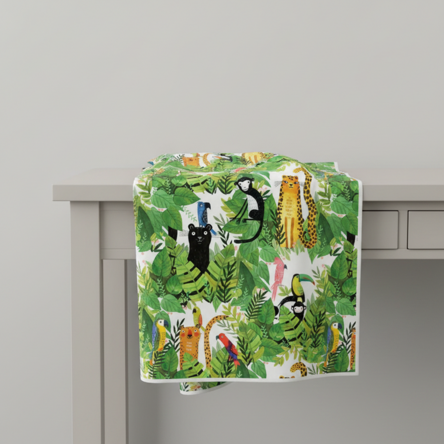 Safari Fun White/Multi quilting cotton draped over a light grey table edge with soft natural folds — large-scale watercolor jungle animal print by Terry Runyan for Benartex | IraRobi Quilts