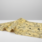 Heat Wave Bask Sun quilting cotton draped on light grey surface — bold black abstract scratch lines and grid squares on golden yellow ground by Katie Pasquini Masopust for FreeSpirit Fabrics