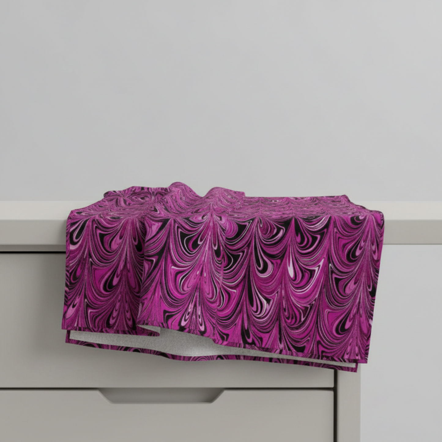 Needle Stars Chandelier Fuchsia fabric draped over table edge showing natural drape and body — marbled fuchsia and black quilting cotton by Paula Nadelstern for Benartex