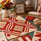 Interwoven Tomato Fabric by Jason Yenter for In The Beginning Fabrics featured as lattice strips and sashing in Echo Effects quilt blocks laid out on a cutting mat on a wooden sewing table — additional cut blocks and folded fabric stacks alongside rotary cutter, scissors, thread, pin cushion, and quilt pattern notebook. White pitcher with sunflowers and "Happiness is Handmade" sign in the background. Quilts shown for inspiration feature the Echo Effects Quilt Pattern — available at IraRobi Quilts.