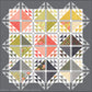 Emilia quilt pattern by Robin Pickens on a dark gray background, featuring large coral, green, gold, and floral triangles with half-square triangle borders