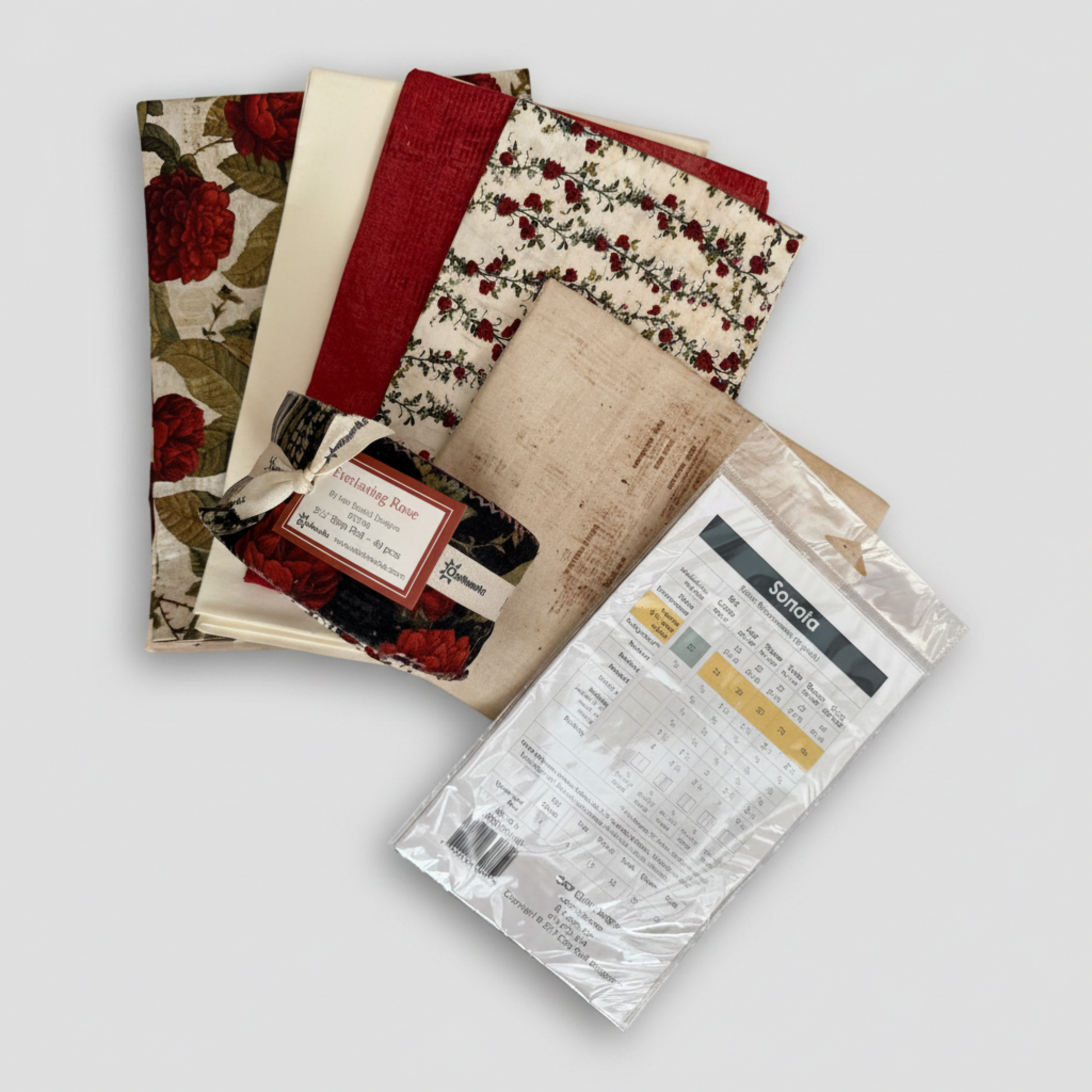 Everlasting Rose Quilt Top Kit – five coordinating cotton fabrics fanned out with Everlasting Rose jelly roll and Sonata quilt pattern back showing fabric requirements chart by Cozy Quilt Designs