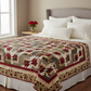 Sonata quilt pattern in Everlasting Rose fabrics by Iron Orchid Designs draped across a neatly made bed with white pillows and red roses – crimson, cream, sage green and burgundy medallion design