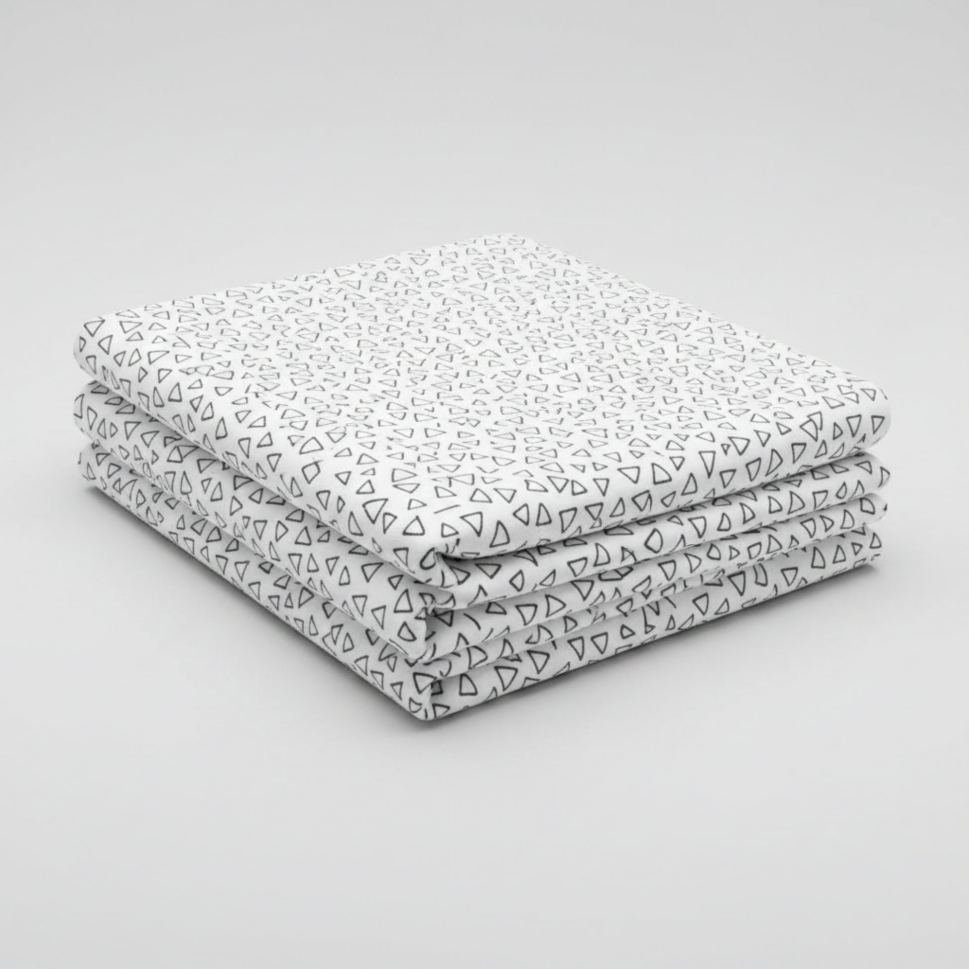 Safari Fun Floating Triangles White/Black by Terry Runyan for Benartex – neatly folded fabric stack on light grey background showing black hand-drawn triangle outlines on crisp white quilting cotton