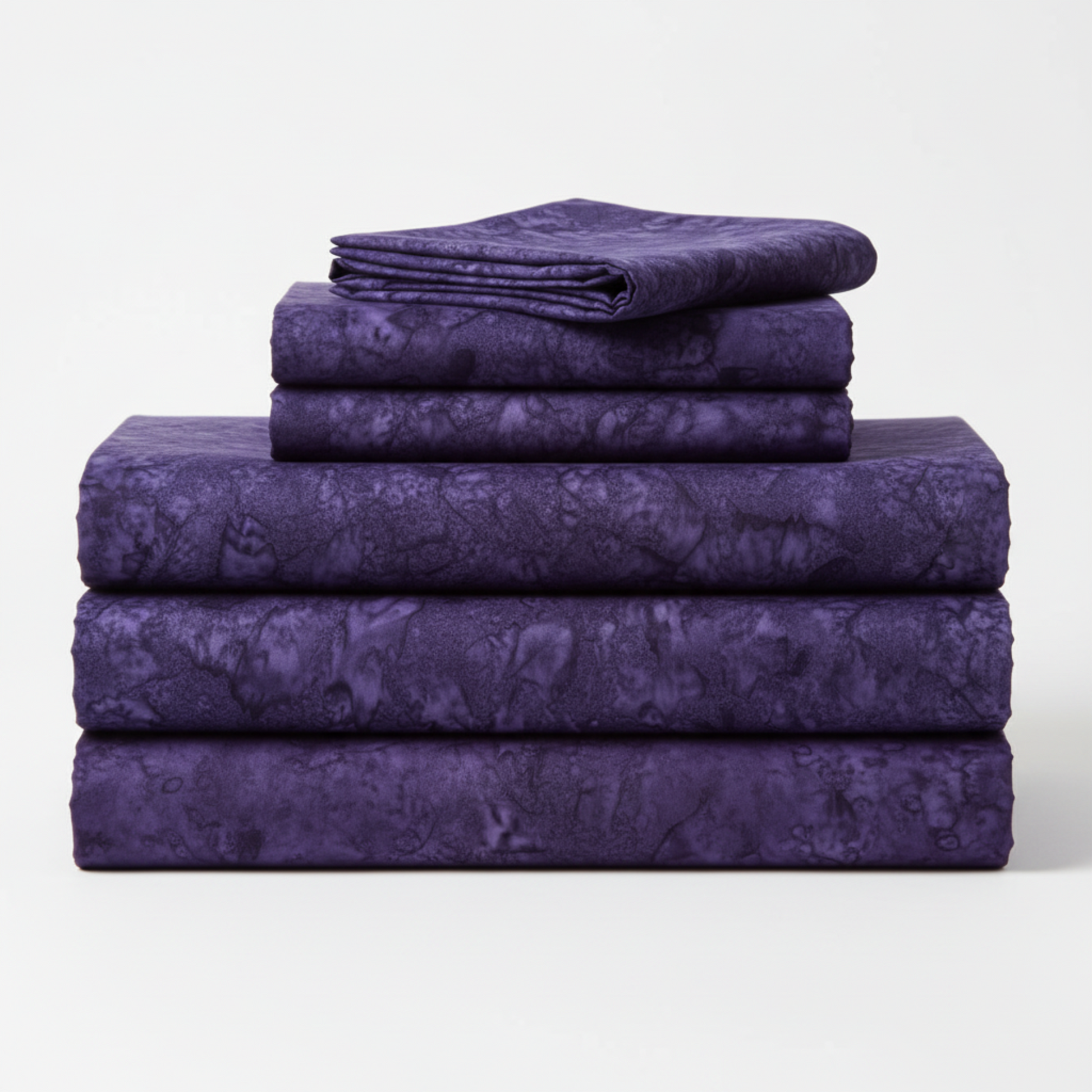 Expressions Batiks Hand-Dyes Dark Purple quilting cotton neatly folded and stacked, showing rich jewel-tone color – by Riley Blake Designs