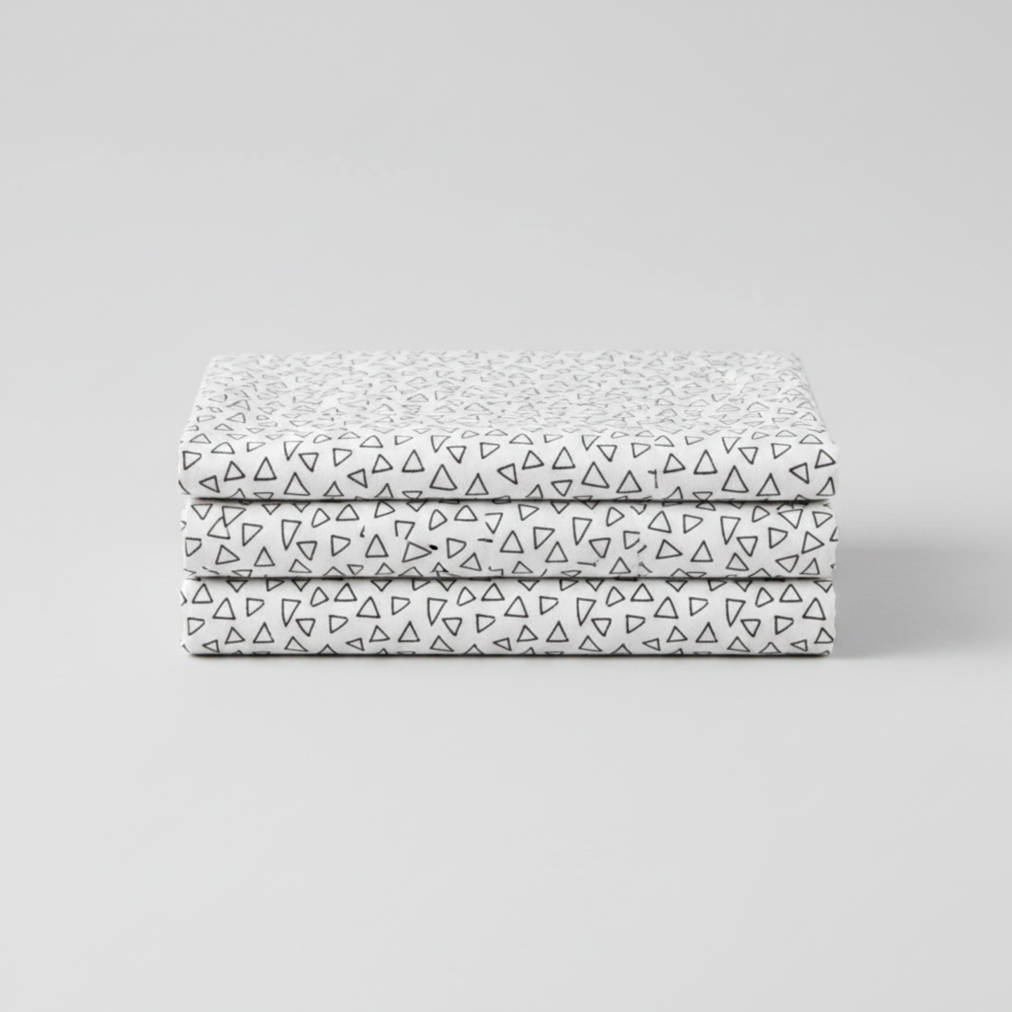 Safari Fun Floating Triangles White/Black fabric folded and stacked — black hand-drawn triangle outlines on white quilting cotton by Terry Runyan for Benartex. 100% cotton, 43–44" wide