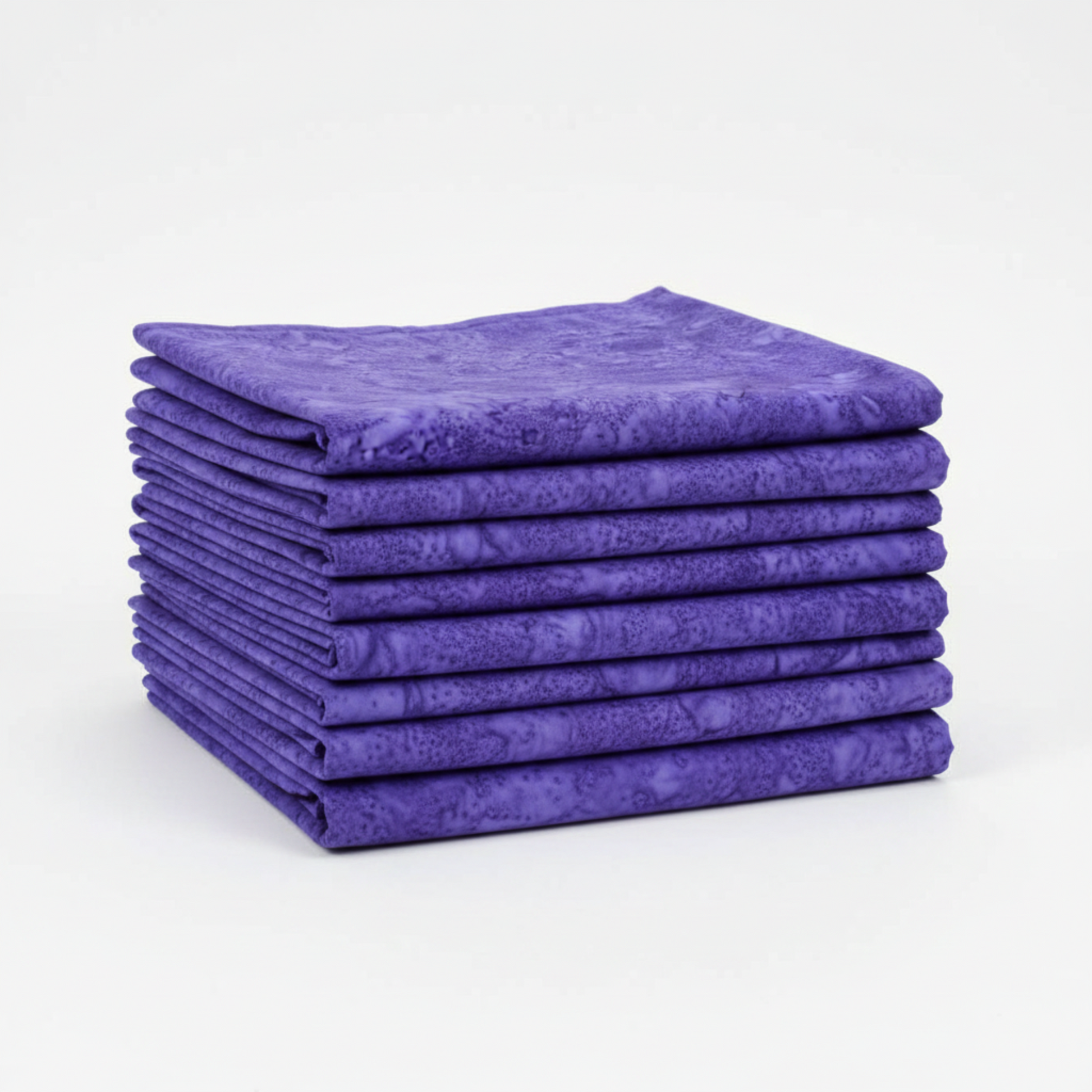 Expressions Batiks Hand-Dyes Purple II quilting cotton neatly folded and stacked, showing rich jewel-tone violet-purple color – by Riley Blake Designs