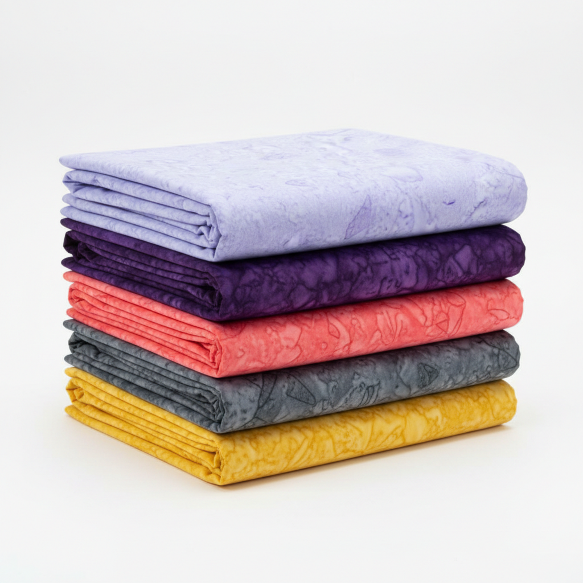 Expressions Batiks Hand-Dyes Periwinkle quilting cotton folded into neat flat yardage and stacked with coordinating hand-dyed batik fabrics in dark purple, coral, charcoal and gold – by Riley Blake Designs at IraRobi Quilts
