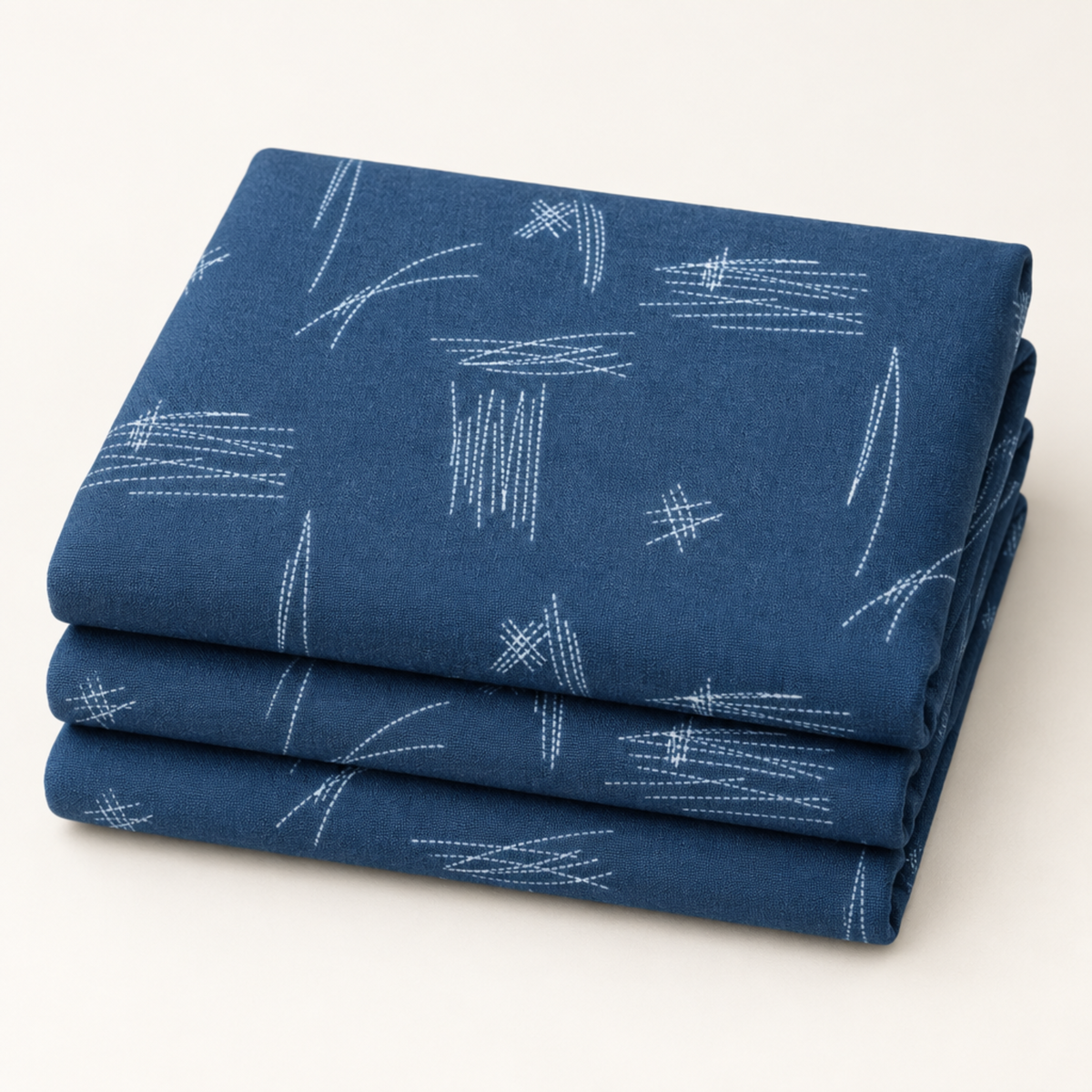 Neatly folded Bluish Stitched Up Blueprint fabric by Zen Chic for Moda Fabrics on a light studio background.