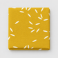 Filigree Rice Saffron fabric by Zen Chic for Moda Fabrics, neatly folded on a light grey background, showing white rice-grain shapes scattered across a saffron-mustard ground.