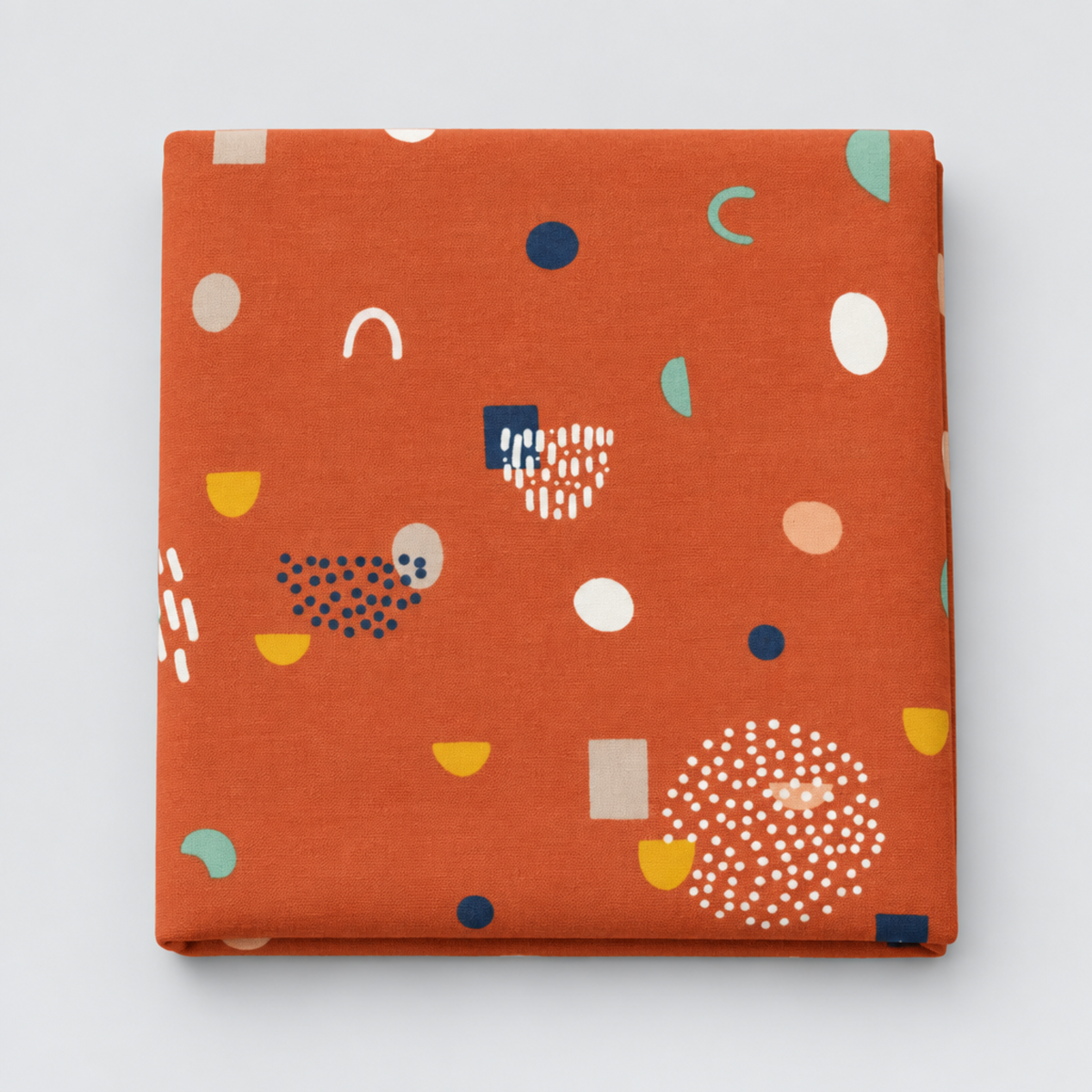 Frisky Catch Me Cheeky fabric by Zen Chic for Moda Fabrics, neatly folded on a light grey background, showing navy, mint, mustard, cream, and blush abstract shapes and dotted clusters on a rust-orange ground.