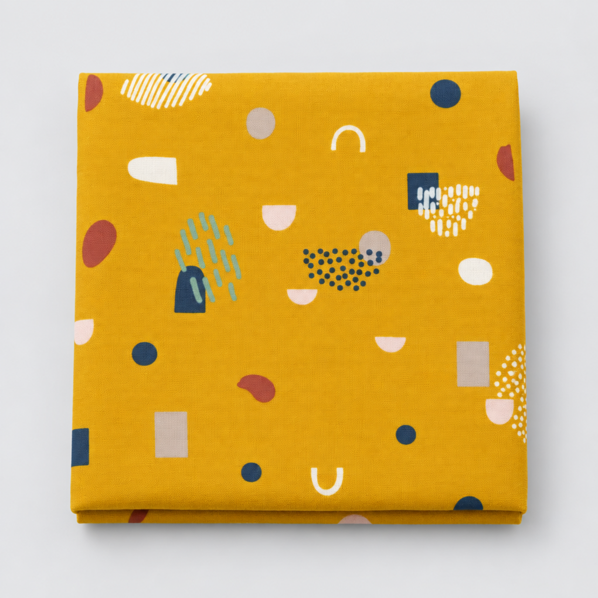 Frisky Catch Me Sunny fabric by Zen Chic for Moda Fabrics, neatly folded on a light grey background, showing navy, rust, cream, blush, and mint abstract shapes on a mustard-gold ground.