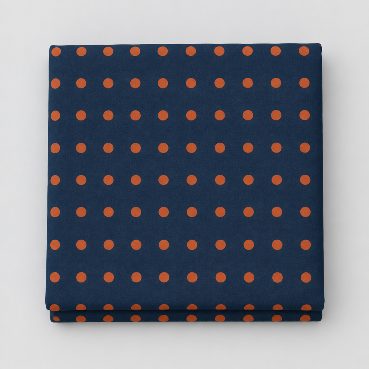 Frisky In A Row Moody fabric by Zen Chic for Moda Fabrics, neatly folded on a light grey background, showing neat rows of rust-orange dots on a deep navy ground.