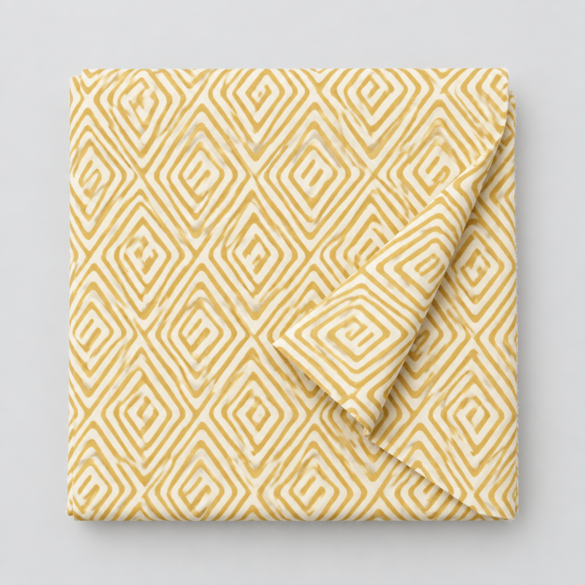 Lazy Afternoon Golden fabric folded with one corner turned back, showing the golden geometric maze print on a cream ground.