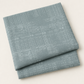 Folded Steel Stamps fabric with a pale grid and distressed stamped print on steel blue, photographed against a light background.