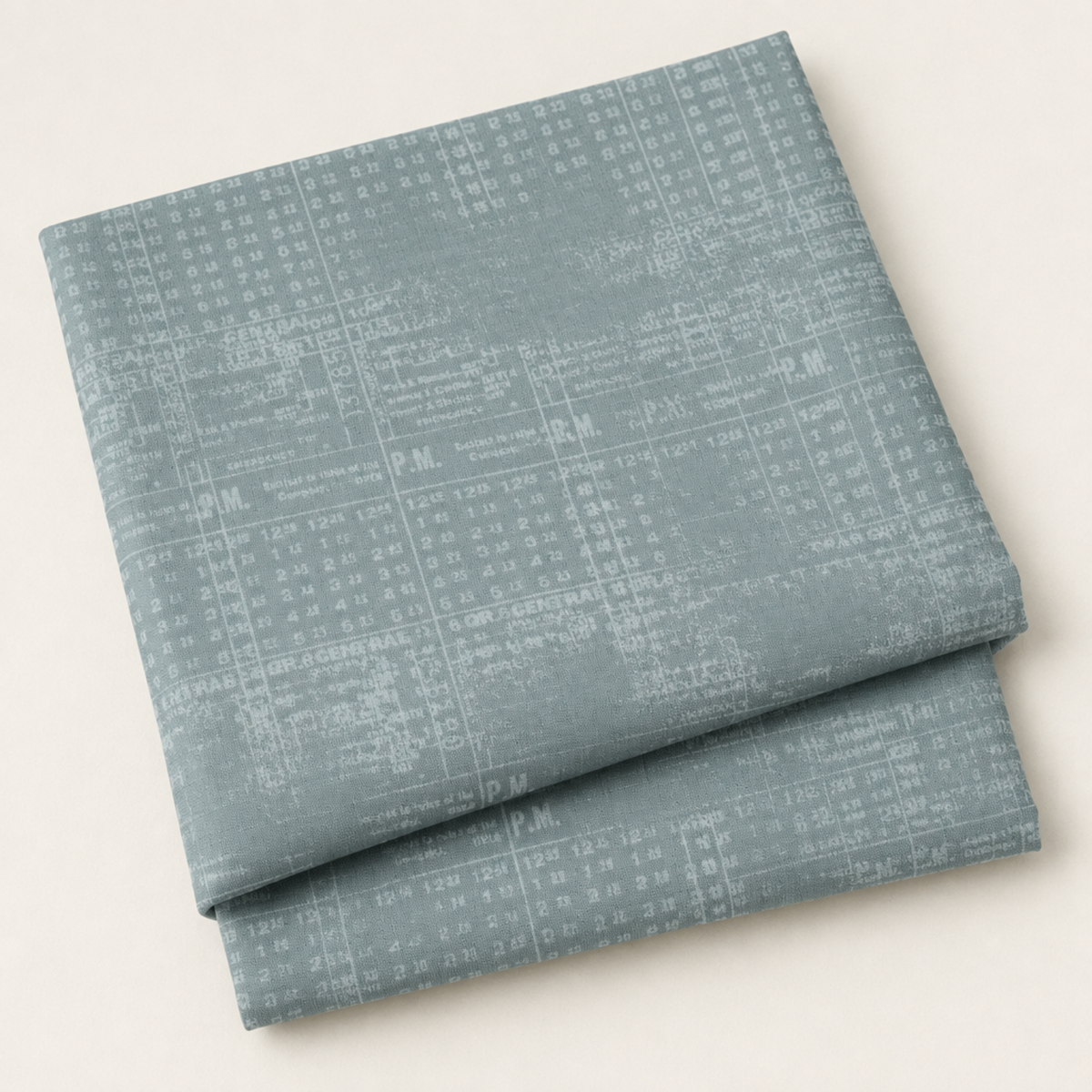 Folded Steel Stamps fabric with a pale grid and distressed stamped print on steel blue, photographed against a light background.