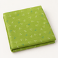Folded Olive You Arrows Leaf fabric showing white and blue-green arrow marks on leaf green, photographed against a light background.
