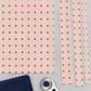 Frisky In A Row Sweetie fabric by Zen Chic for Moda Fabrics laid flat with cut strips, a rotary cutter, and a folded navy coordinating fabric. Available at IraRobi Quilts.