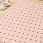 Frisky In A Row Sweetie fabric by Zen Chic for Moda Fabrics spread across a light wooden sewing table in a bright studio with a spool of thread, a pin dish, and scissors. Available at IraRobi Quilts.