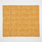 Autumn Celebration Gold Berries quilting cotton — unfolded flat lay on white surface showing the full scattered dot cluster pattern across the golden amber ground with raw cut edges visible. Low-contrast tonal blender. 100% cotton, 43–44" wide.