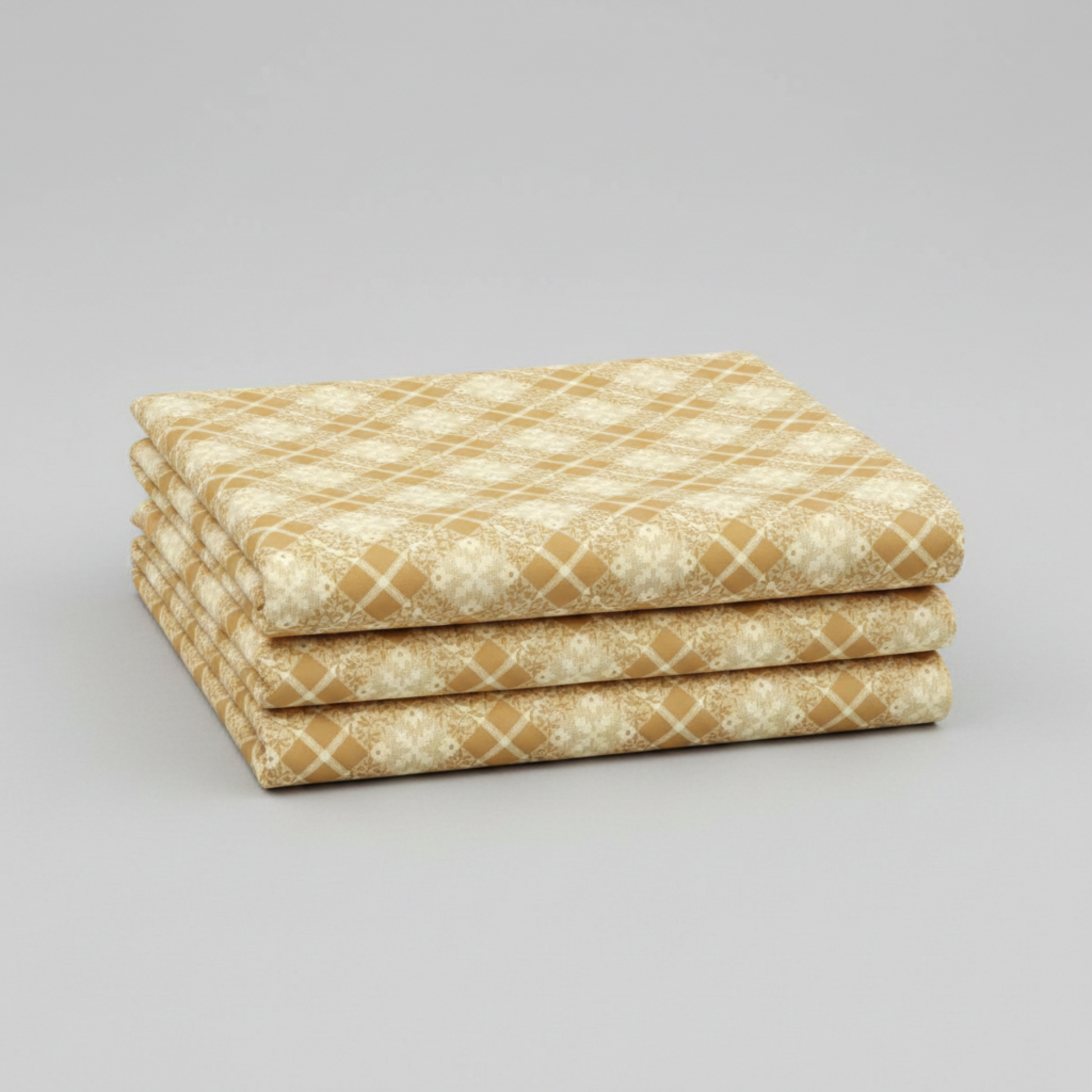 Golden Era Floral Plaid Tan quilting cotton by Paula Barnes for Marcus Fabrics — three folded yards stacked on a grey surface, warm tan-gold diagonal lattice with cream floral wreath motifs in each diamond cell