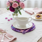Handmade Violet Bloom quilted leaf hot pad under a white ceramic gravy boat with pink and purple flowers | IraRobi Quilts #handmadekitchen #cottagestyle"
