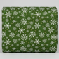 Winter Solstice II Green Snowflakes Metallic quilting cotton by Jason Yenter for In The Beginning Fabrics — folded fabric bolt showing tossed white snowflakes in multiple sizes with tiny gold metallic star dots on rich deep forest green mottled ground, 100% cotton with metallic accents, 43–44" wide. Quilt blocks shown for inspiration. Coordinating fabrics and quilt patterns are available at IraRobi Quilts.
