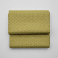 Golden Era by Paula Barnes, Wavy Daisy Green quilting cotton for Marcus Fabrics — neatly folded fabric showing soft sage-olive green ground with all-over tossed wavy-outline daisy motif in brown-taupe with yellow-gold centers, 100% cotton 43–44" wide