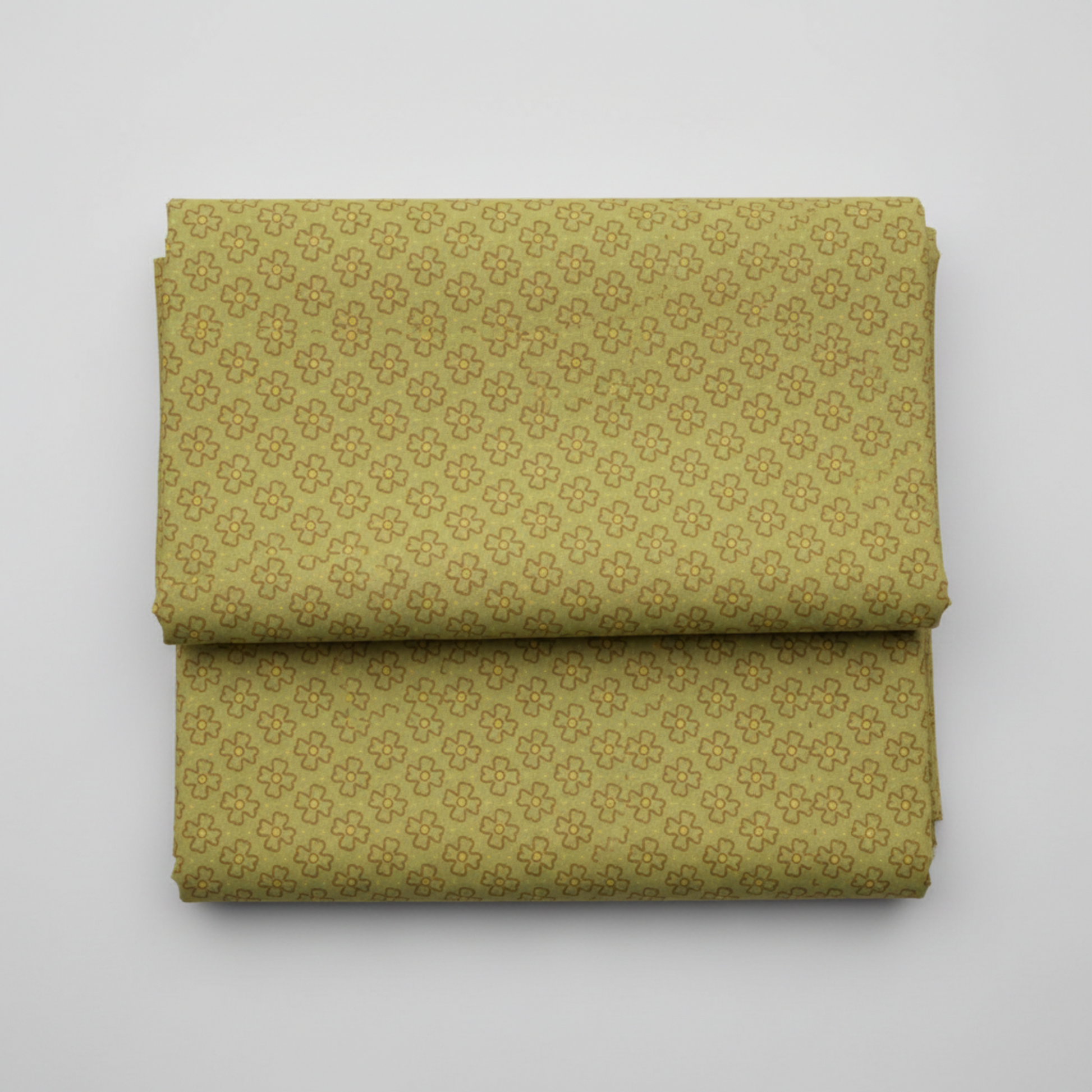 Golden Era by Paula Barnes, Wavy Daisy Green quilting cotton for Marcus Fabrics — neatly folded fabric showing soft sage-olive green ground with all-over tossed wavy-outline daisy motif in brown-taupe with yellow-gold centers, 100% cotton 43–44" wide