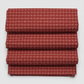 Golden Era by Paula Barnes, Plaid Dot Red quilting cotton for Marcus Fabrics — neatly folded fabric showing deep crimson-red ground with tonal plaid grid texture and rows of rose-pink honeycomb dot clusters, 100% cotton 43–44" wide