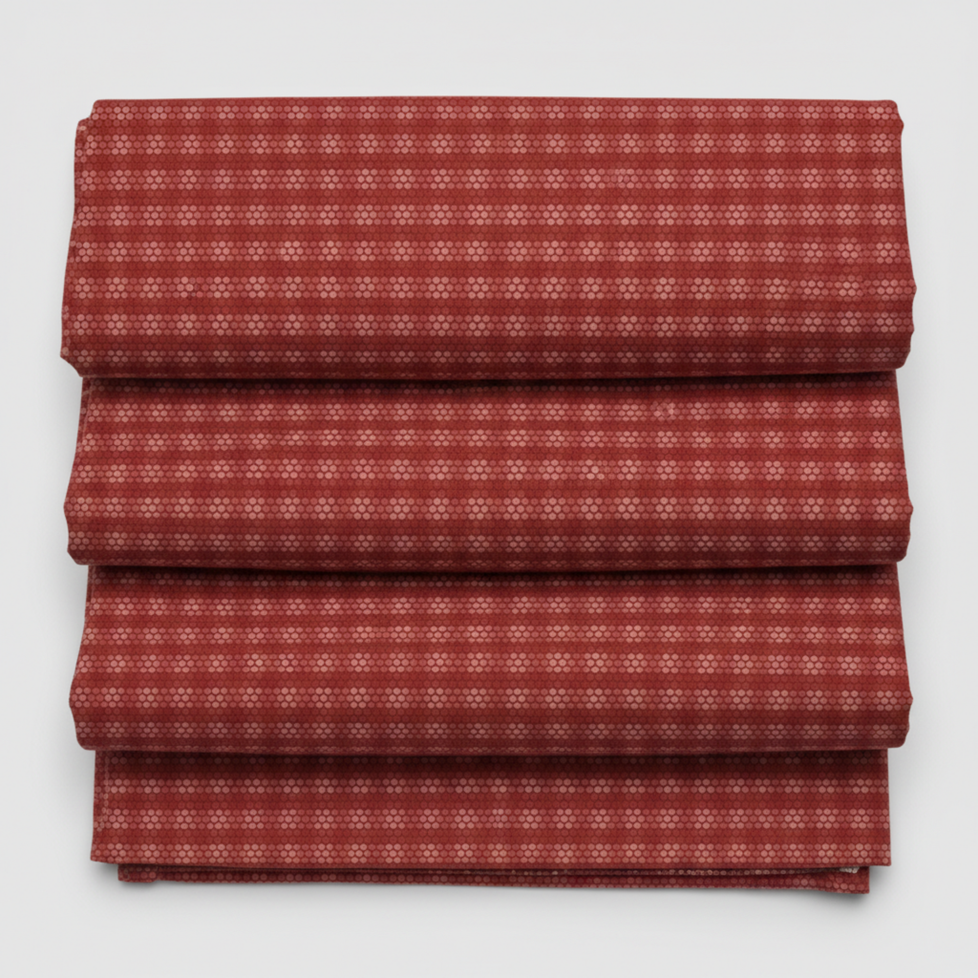 Golden Era by Paula Barnes, Plaid Dot Red quilting cotton for Marcus Fabrics — neatly folded fabric showing deep crimson-red ground with tonal plaid grid texture and rows of rose-pink honeycomb dot clusters, 100% cotton 43–44" wide