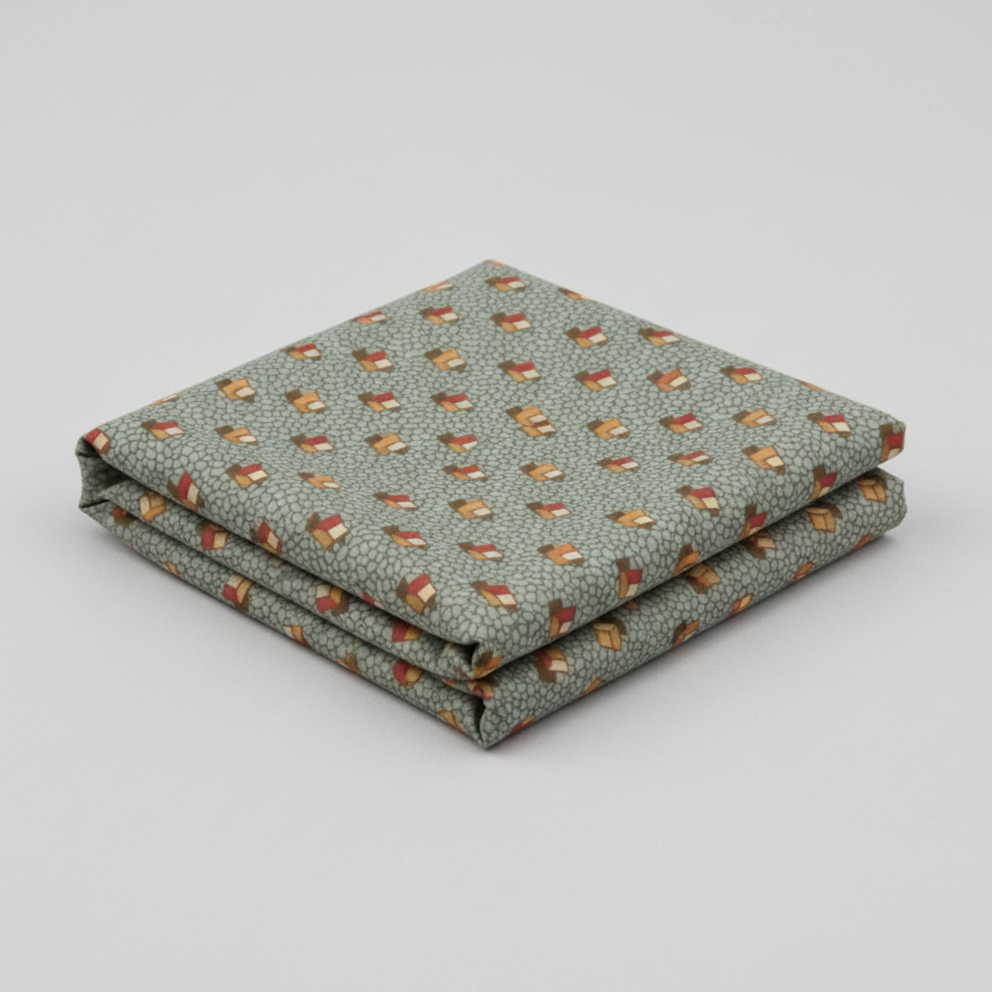 The Fox Homestead Slate Blue Green Tossed Cubes quilting cotton by Stacy West for Henry Glass — neatly folded fabric showing muted slate blue-green pebble ground with tumbling cube motifs in gold, cream, and burgundy