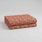 The Fox Homestead Pink Leaves And Berries quilting cotton by Stacy West for Henry Glass — neatly folded fabric showing dusty rose-terracotta ground with leaf-and-berry sprigs in gold, cream, and burgundy