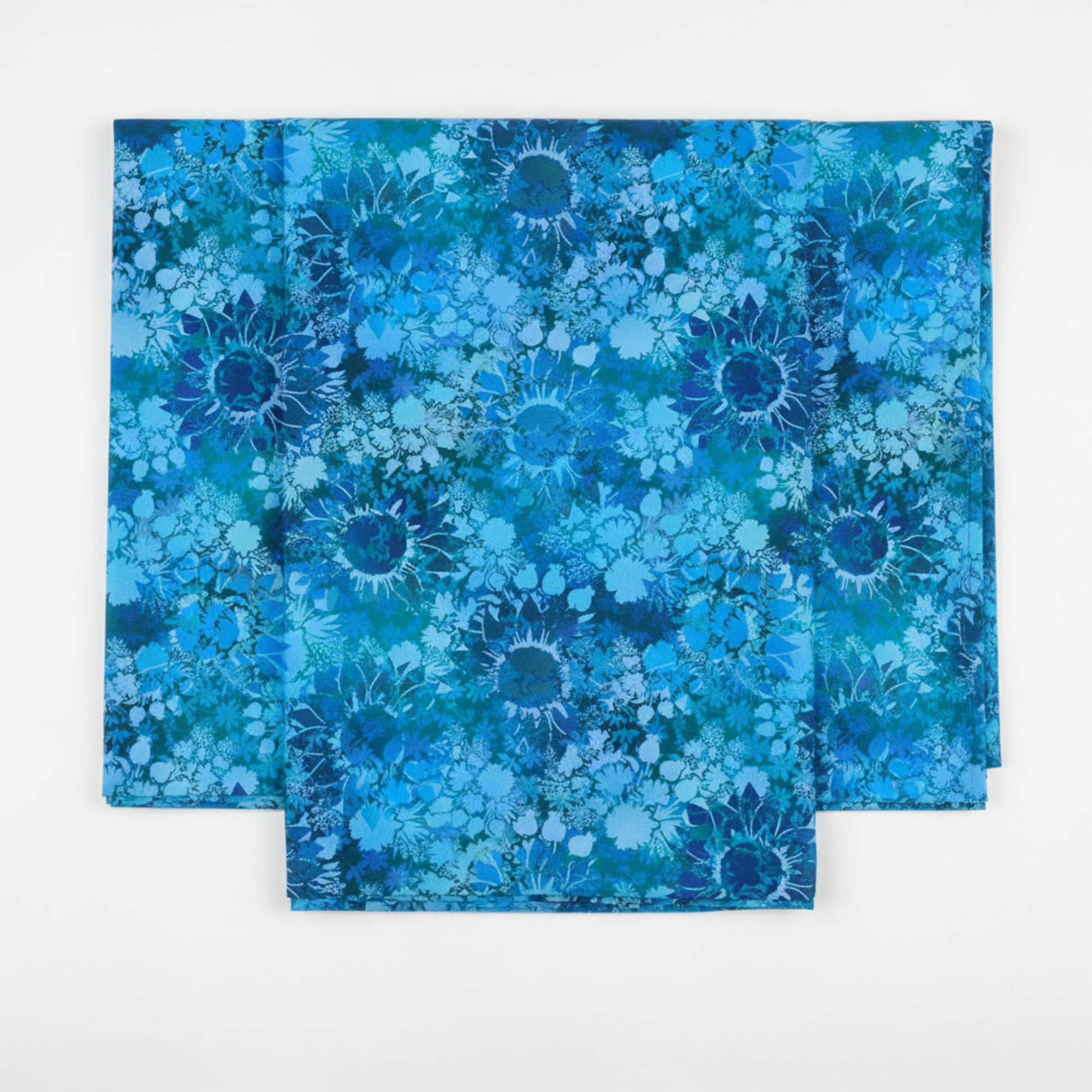 I Dream In Color Sunflower Blue quilting cotton fabric folded to show allover tonal shadow floral – silhouetted sunflowers, daisy clusters, berry sprigs, and leaves in vibrant cobalt, cerulean, teal, and deep navy watercolor wash by Jason Yenter for In The Beginning Fabrics, 100% cotton, 3 yard cut