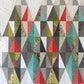 Harlequin quilt pattern by Robin Pickens – lifestyle shot showing full colorful diamond quilt in two sizes 49x71 and 61x83 inches – Shop at IraRobi Quilts