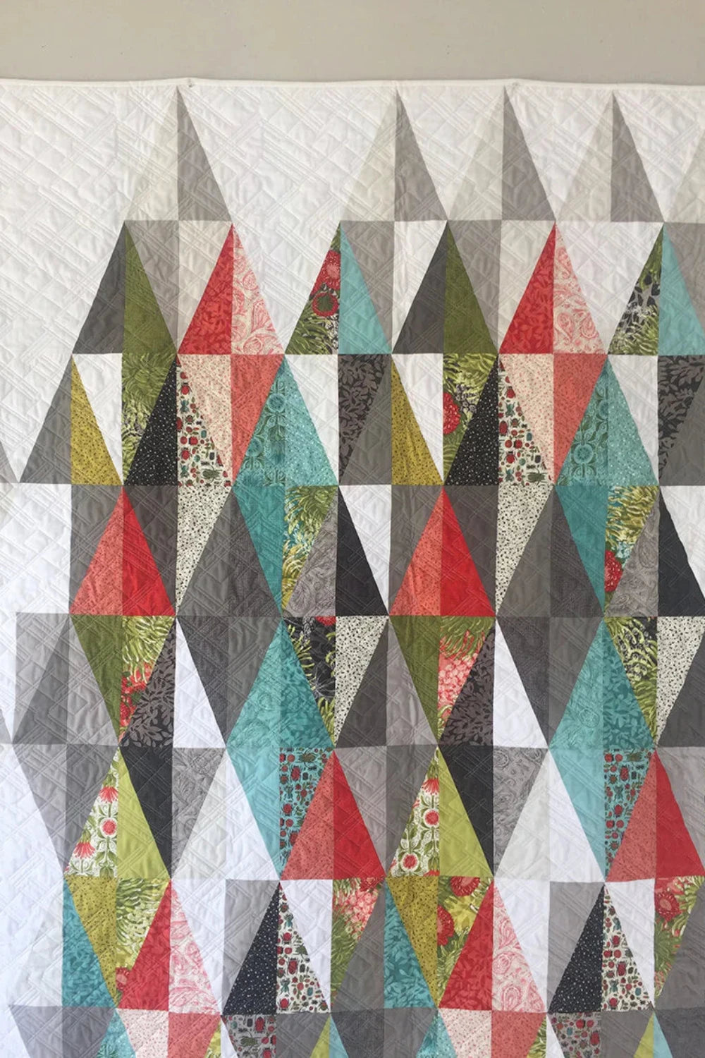 Harlequin quilt pattern by Robin Pickens – lifestyle shot showing full colorful diamond quilt in two sizes 49x71 and 61x83 inches – Shop at IraRobi Quilts