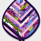 Leaf-Shaped Quilted Hot Pad – Indigo Berry, slightly angled editorial product shot on light grey background with soft natural shadow and hanging loop visible – handmade by IraRobi Quilts