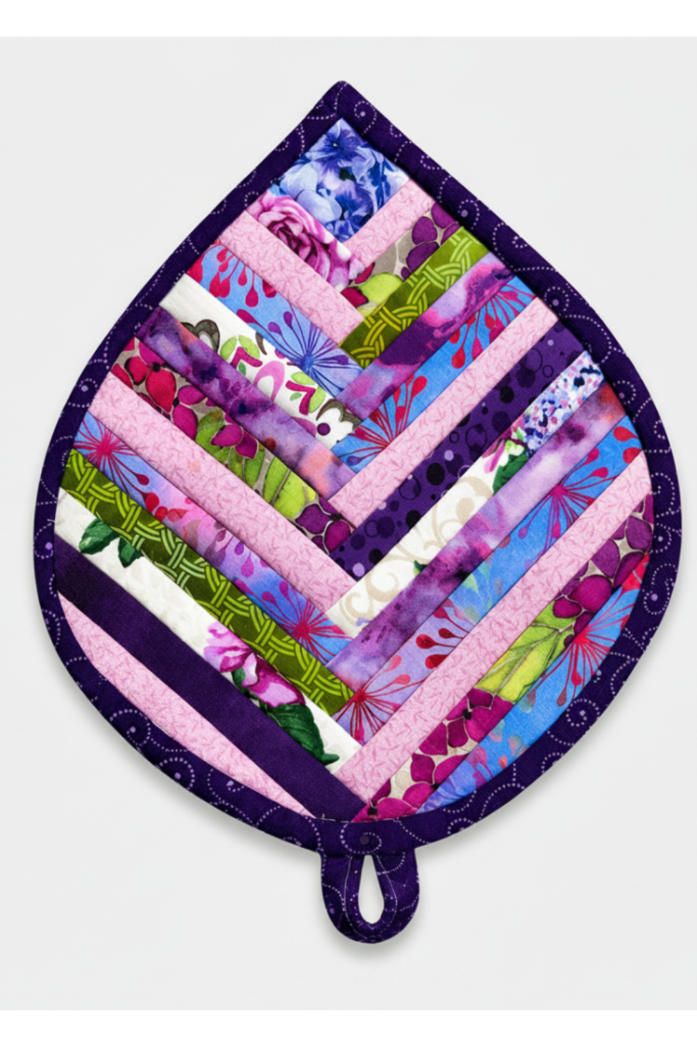 Leaf-Shaped Quilted Hot Pad – Indigo Berry, slightly angled editorial product shot on light grey background with soft natural shadow and hanging loop visible – handmade by IraRobi Quilts