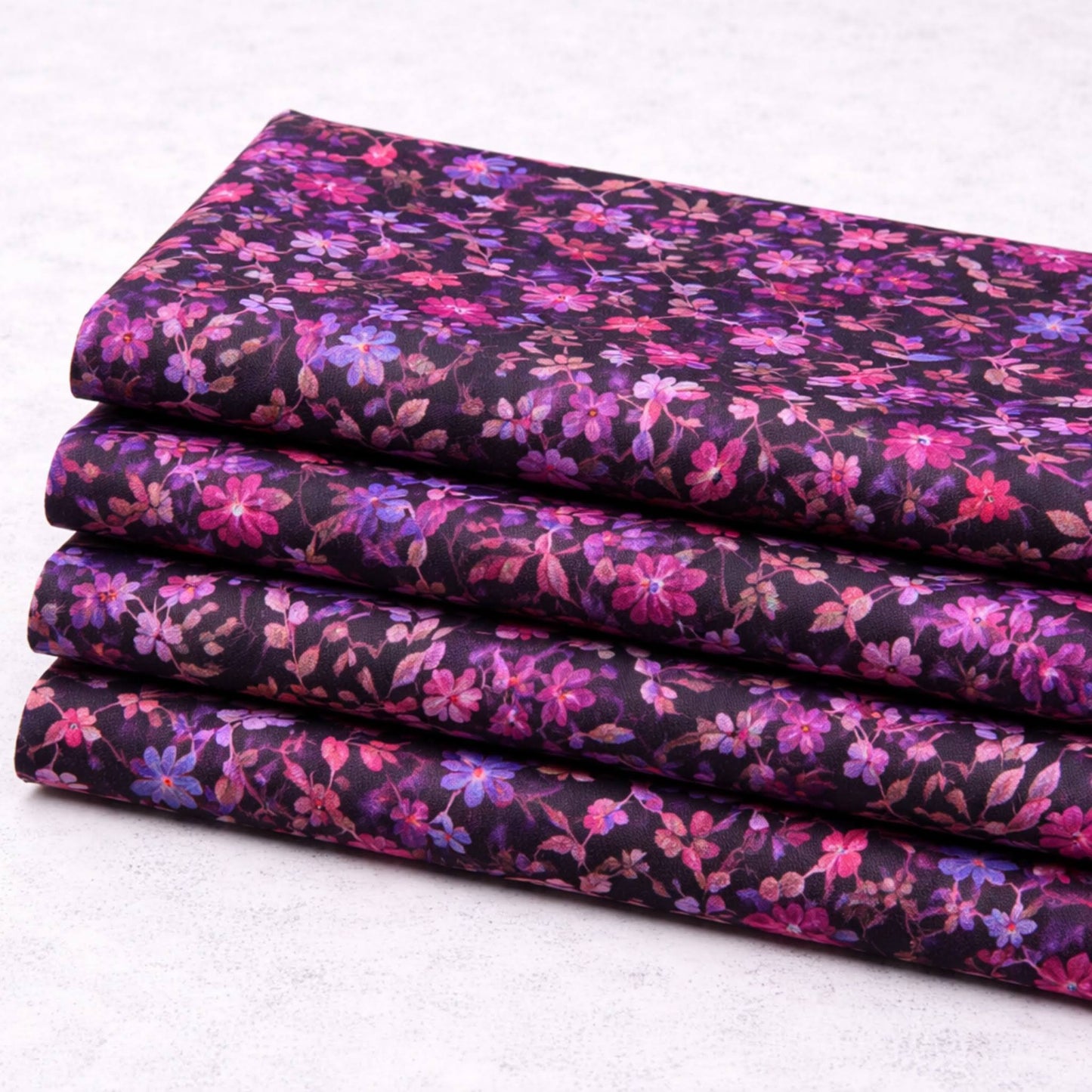 Halcyon II Magenta Vines fabric stacked in four folded cuts showing small pink, magenta, and blue floral print on deep purple-black cotton by Jason Yenter for In The Beginning Fabrics