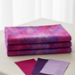 Three yards of Impressions Magenta Dots quilting cotton fabric neatly folded and stacked, with magenta, purple, and lavender color swatches – by Jason Yenter for In The Beginning Fabrics, 100% cotton