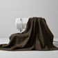 Interwoven Bark Fabric by Jason Yenter for In The Beginning Fabrics draped over a sewing machine with soft natural folds showing the very dark brown geometric crosshatch print